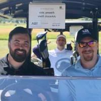 2 more football alumni in a golf cart